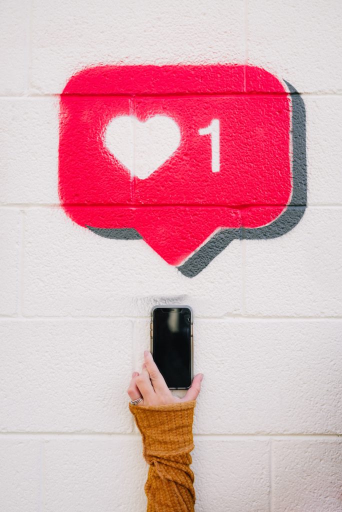 Image of love social media notification and hand holding a phone.